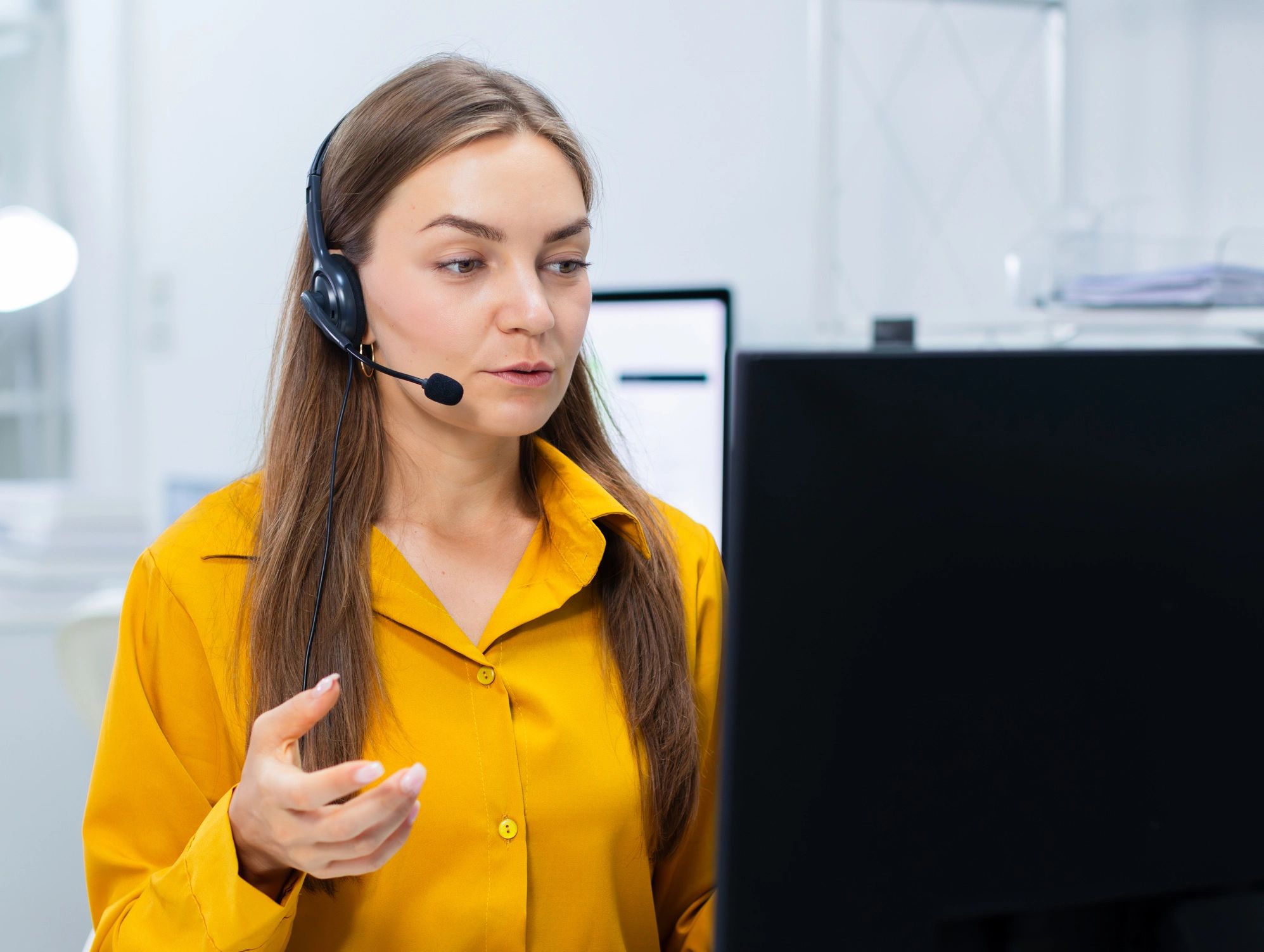 Agente de soporte técnico atendiendo con auriculares en oficina moderna